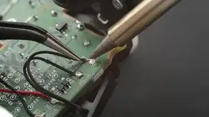 Use your soldering iron to heat up one of the motor wire solder pads.