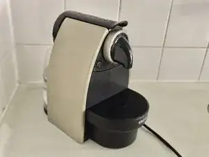 Krups ESSENZA Nespresso demontage om geblokkeerde uitvoer te reinigen.
