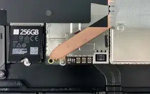 <strong>Demontage-update</strong>: Het blijkt dat het mysterieuze batterij-icoontje een bijbehorend <a href="../../home/external_content?url=https%3A//d3nevzfk7ii3be.cloudfront.net/igi/46vUpgaJwIDKTd4W" rel="nofollow noopener noreferrer">status indicatielampje</a> heeft! Het lijkt erop dat wanneer het bord geladen is, het lampje gaat branden. Het verbinden van de pinnetjes zorgt er niet voor dat het lampje uit gaat, maar het verwijderen van de SSD wel...