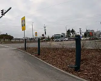 Simple bollards with a foot peg and and a handhold. highway=cyclist_waiting_aid handrest=yes footrest=yes direction=(forward/backward) side=right material=metal capacity=3 (For a two-way cycleway, direction=* specifies which travel direction along the OSM way the aids are intended for. Using capacity=*, because each bollard only support one cyclist.)