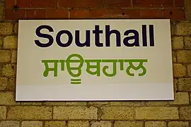 Bilingual English and Punjabi (Gurmukhi) sign at Southall railway station in the London, UK