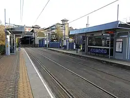 bright yellow strip with coloured oval shaped bumps in front of a tram platform