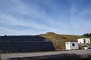 Capped, visible landfill with partial cover for gas harvesting