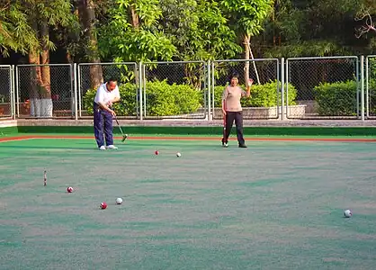 People playing gateball or a variant in Haikou People's Park, Haikou City, Hainan Province, China