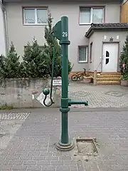 ...aus drei Teilen (Brunnenständer als "Fuß", Rohr mit Wasseraustritt, Schwengeleinheit als "Kopf").