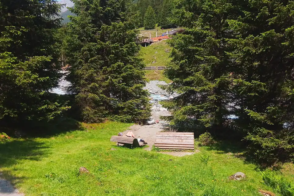 A wave lounger of seats=2-3 next to an ordinary bench